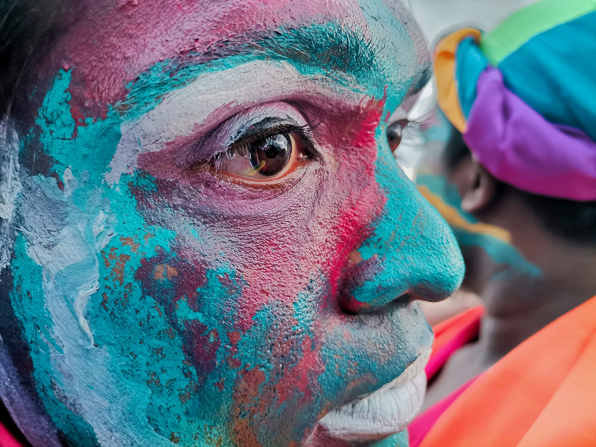 Close-up of a person's face that is painted blue and purple.