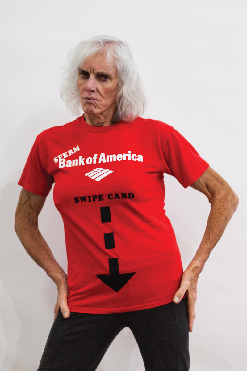 An elderly white trans woman is wearing a red shirt that says sperm bank of america. An arrow points to her crotch and reads "swipe card."