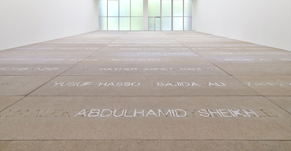 View of a museum's floor with the names of people spelled out by water.