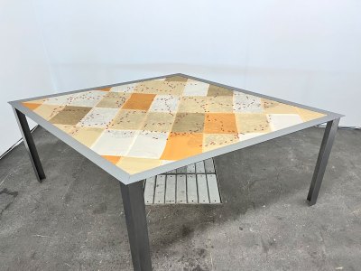 A table with a patchwork artwork on top.