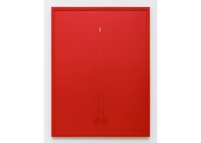 A monochrome photograph of a red candle on a red background with a red frame.